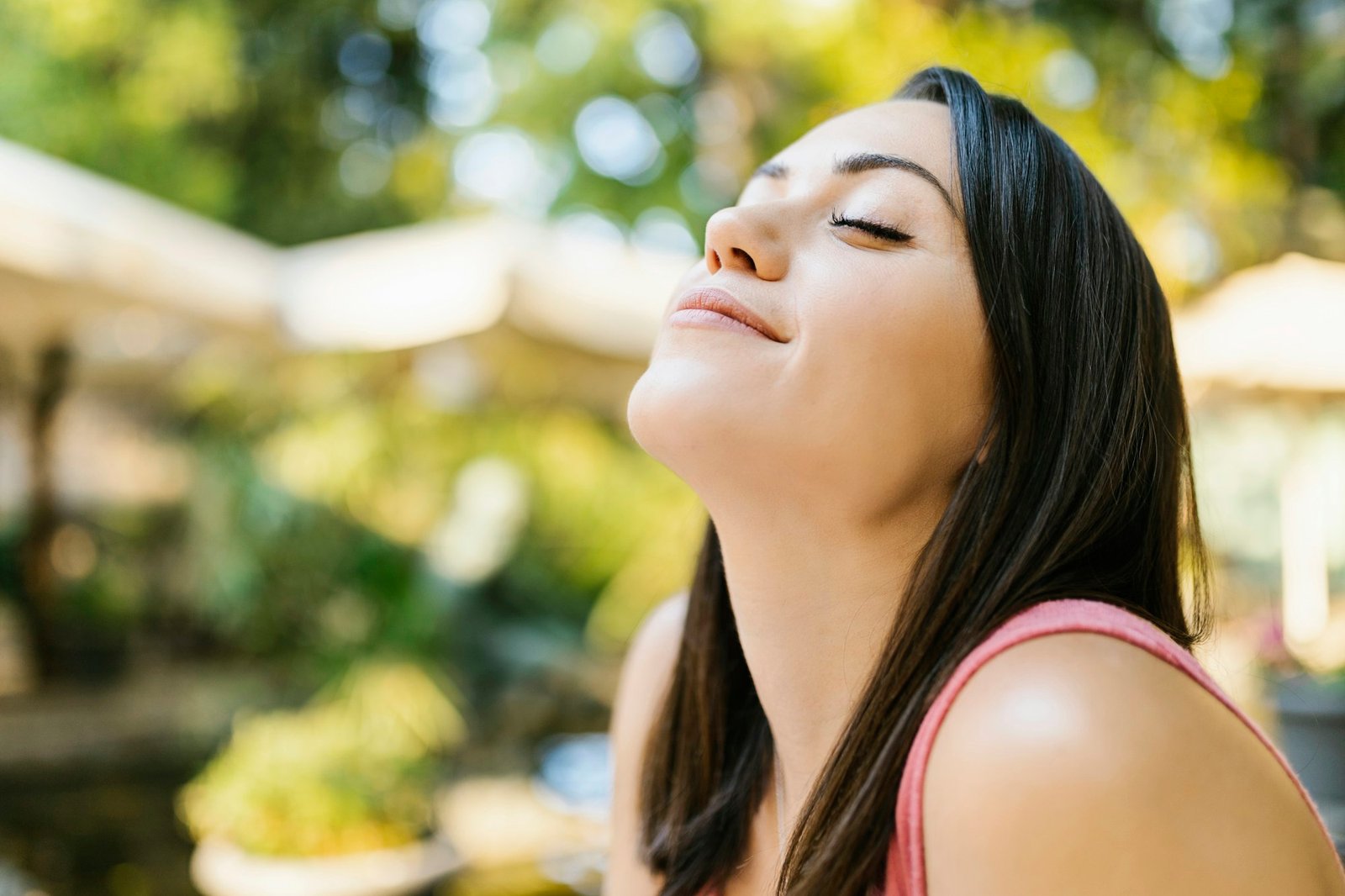 Healthy young adult woman breathing fresh air in the park